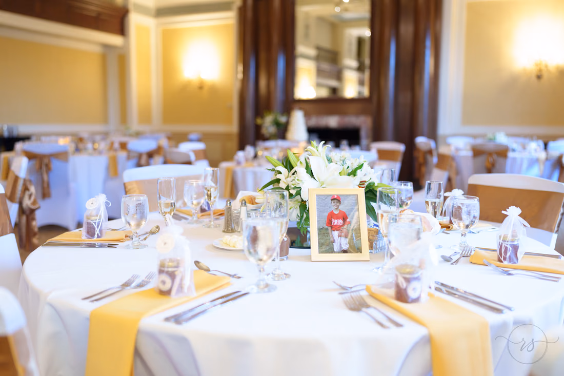 Place settings with gold napkins and a framed photo - Francis Marion Charleston