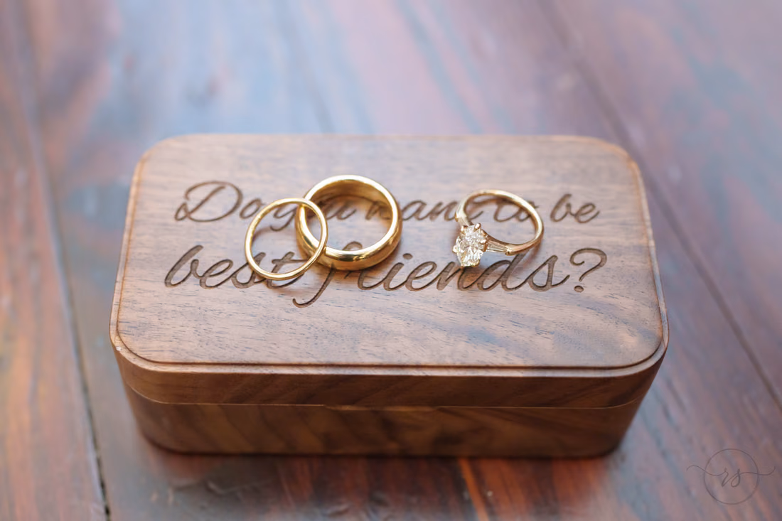 Wedding bands resting on an engraved wooden ring box - Cathedral of Saint John Charleston