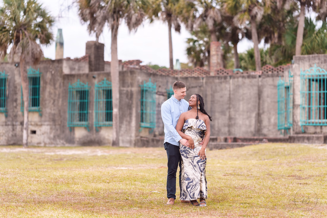 Couple embracing on the lawn in front of Atalaya Castle - Huntington Beach State Park