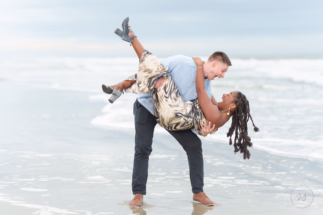 He dips her back by the waves, her boots in the air - Huntington Beach State Park