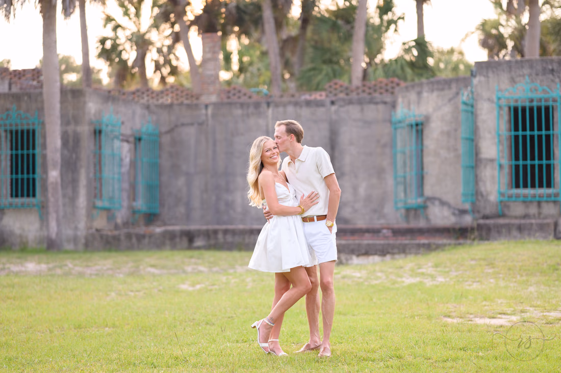 Couple kissing on the lawn in front of Atalaya Castle - Huntington Beach State Park