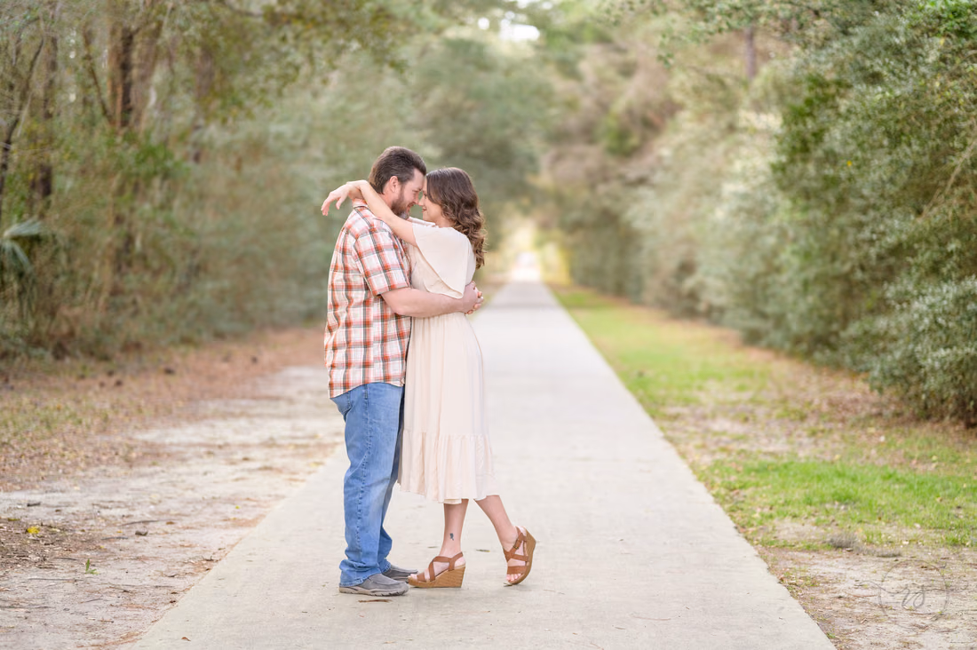 Couple kissing on the long tree-lined path near Atalaya Castle - Huntington Beach State Park