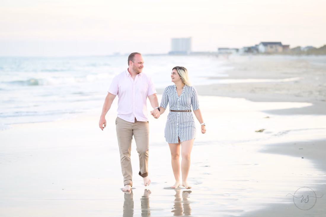 Couple walking hand in hand along the water's edge - Myrtle Beach State Park