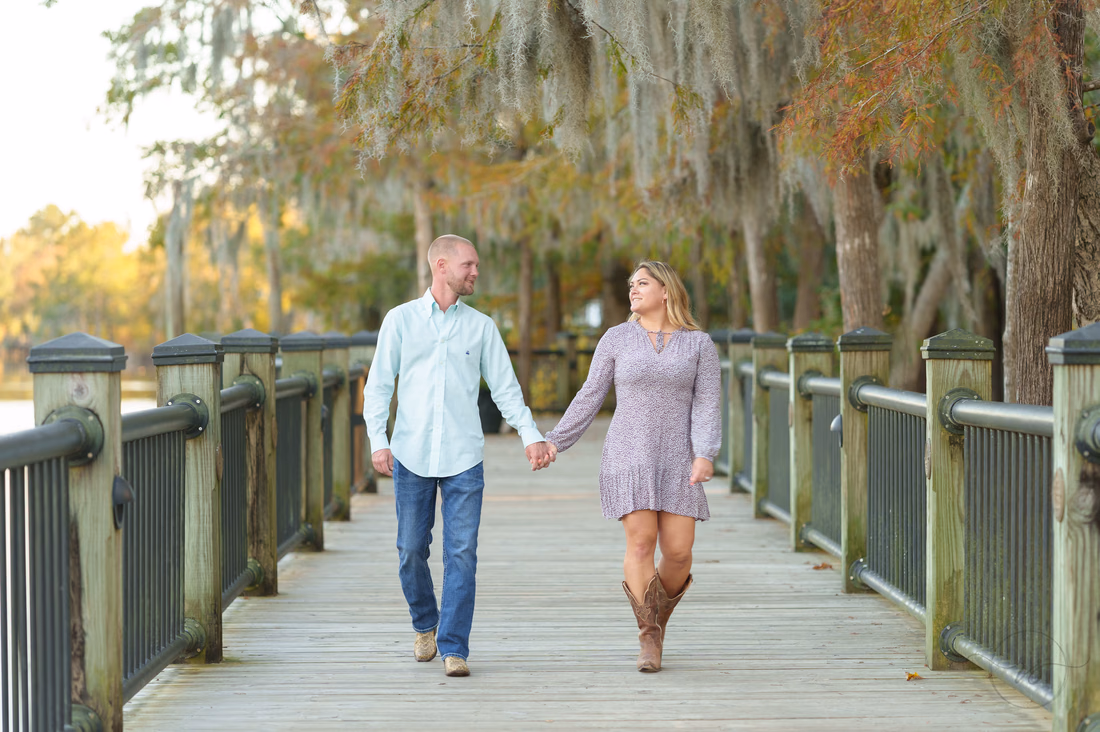 Couple walking hand in hand on the boardwalk - Conway River Walk