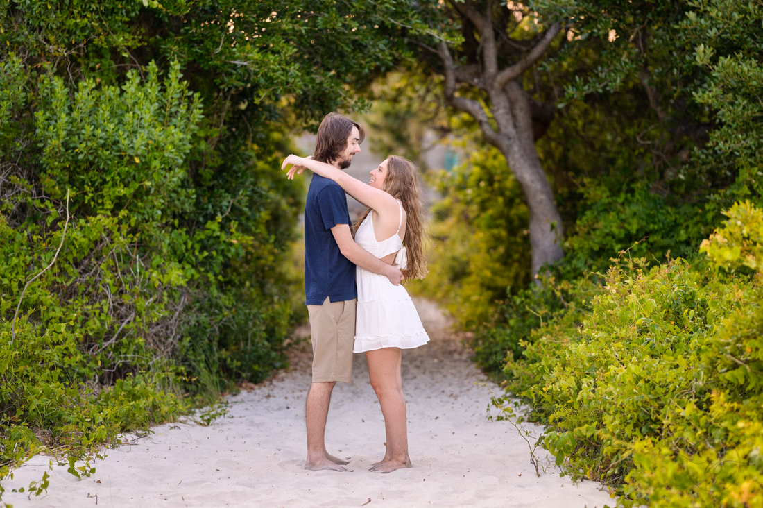 Couple hugging on the sandy beach path - Huntington Beach State Park