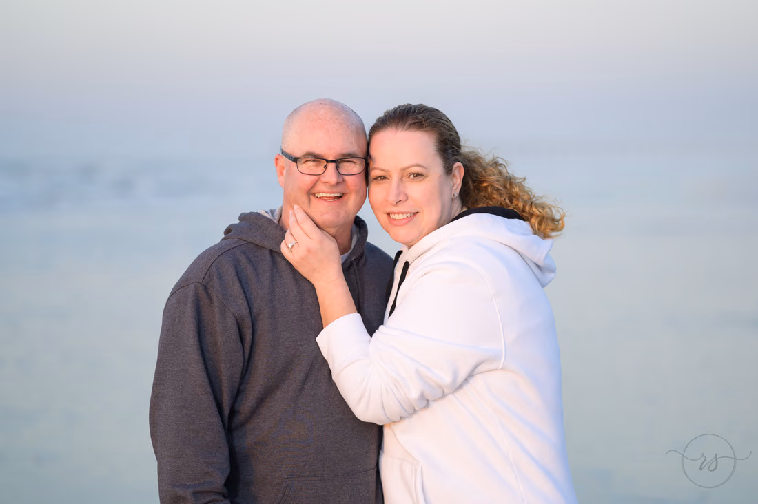 Close portrait of the older couple smiling on the beach at sunrise - Ocean Isle