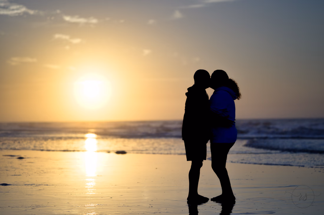 Silhouette of the couple kissing in front of the rising sun - Ocean Isle