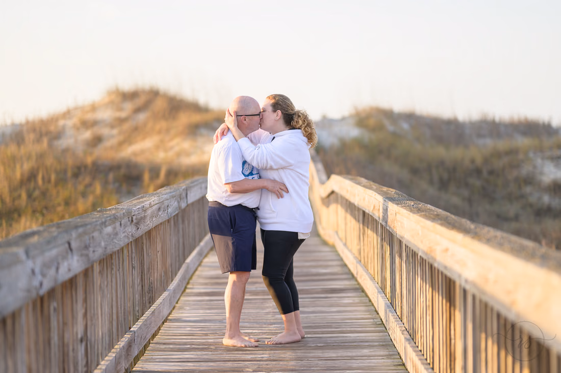 Older couple kissing on the beach access boardwalk - Ocean Isle