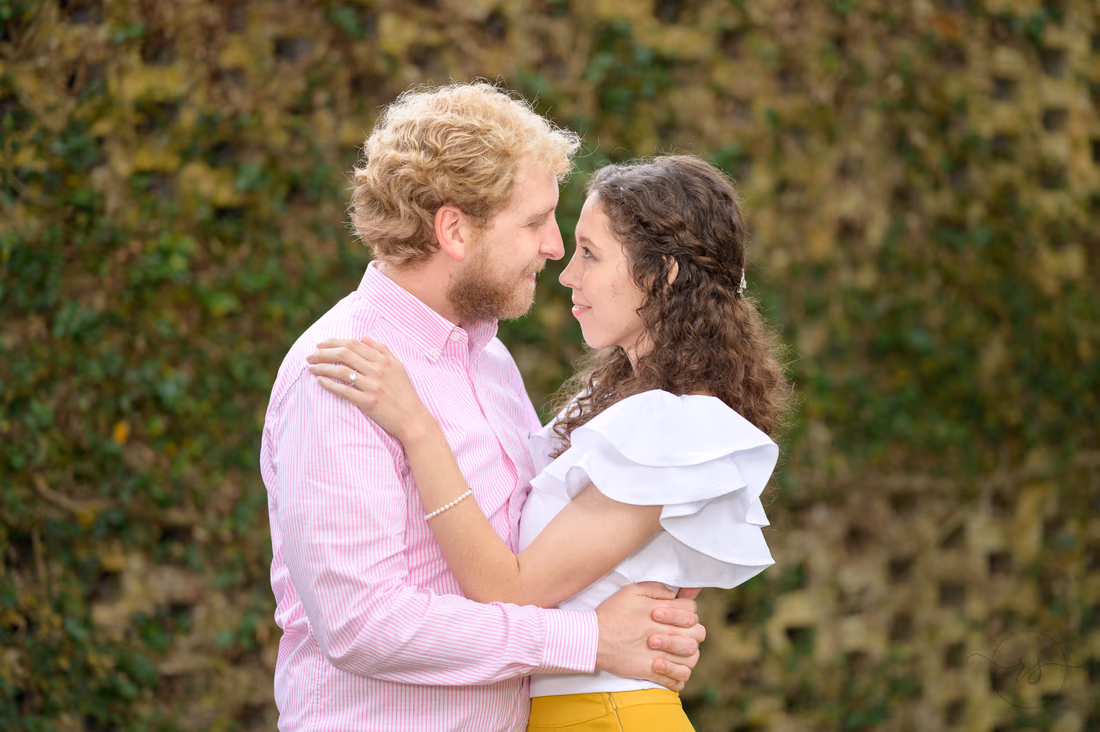 Couple embracing in front of the ivy-covered wall - Huntington Beach State Park
