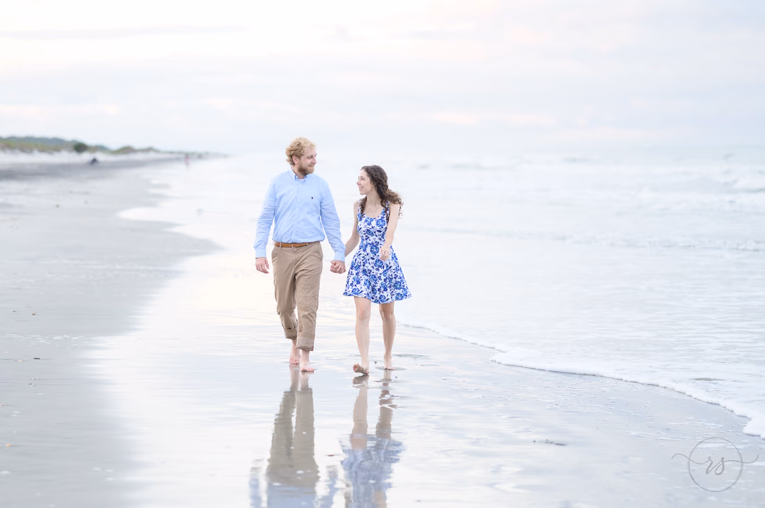 Couple walking hand in hand at the water's edge - Huntington Beach State Park