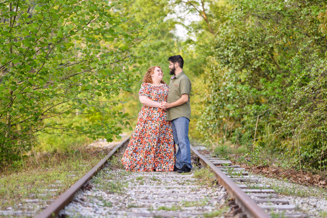 Couple standing close together on the old train tracks - Conway Riverwalk
