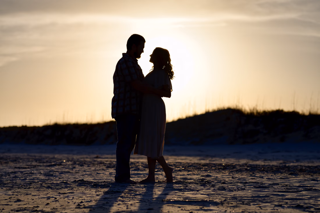 Silhouette of the couple at sunset by the dunes - Huntington Beach State Park