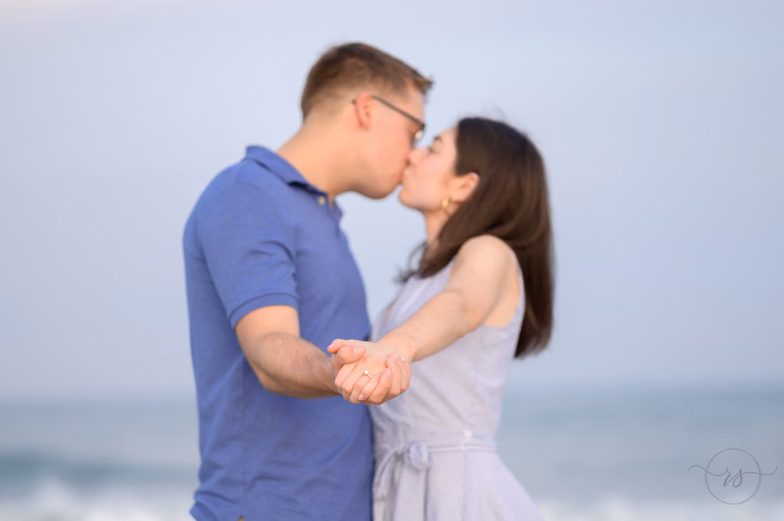 Couple kissing as they hold hands in a dance pose - Huntington Beach State Park