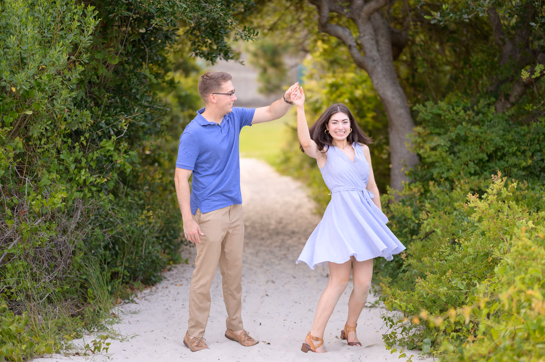 He twirls her on the sandy path to the beach - Huntington Beach State Park