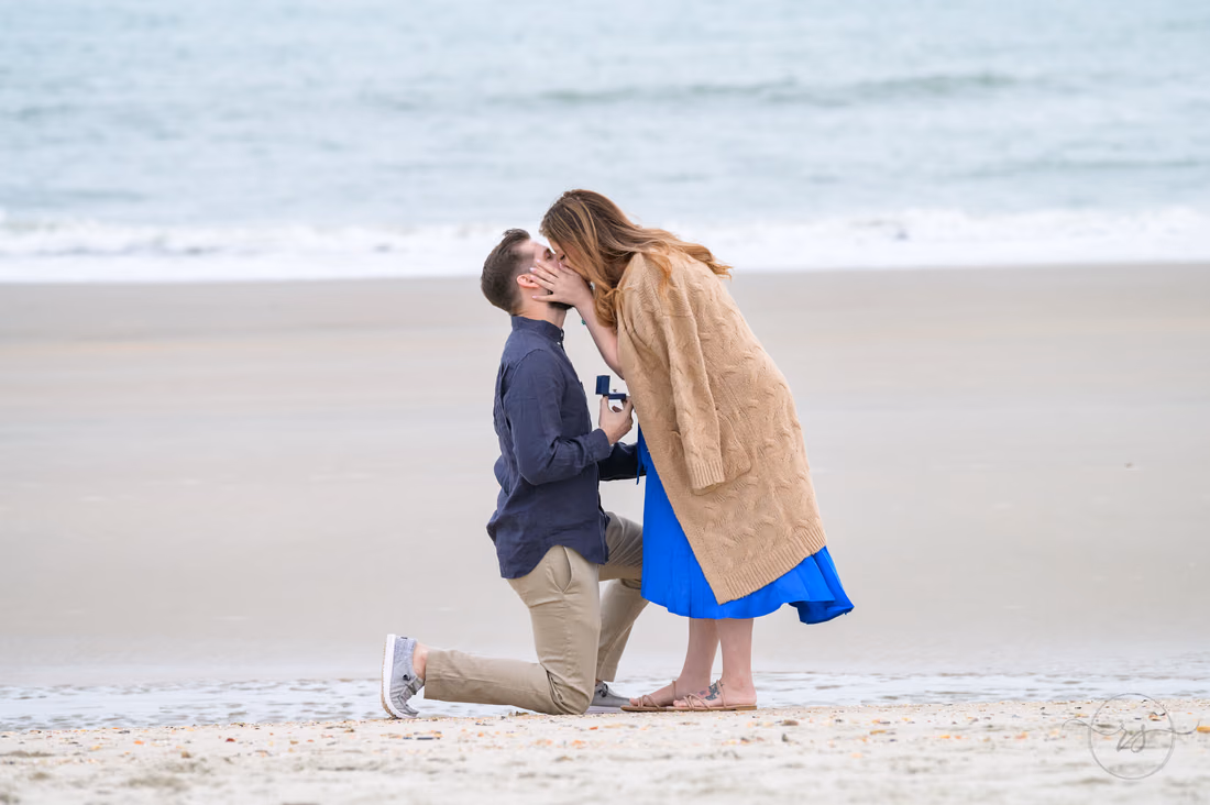 He kisses her while still on one knee after the proposal - Huntington Beach State Park