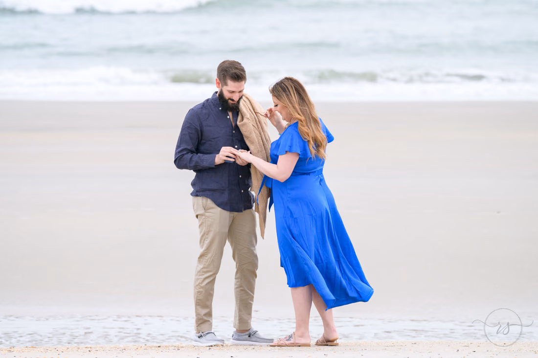 Putting the engagement ring on her finger on the beach - Huntington Beach State Park
