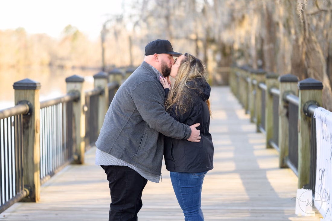Couple kissing right after the proposal on the boardwalk - Conway River Walk