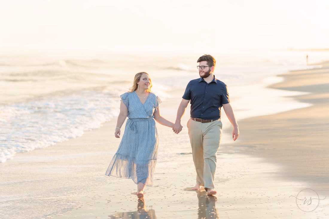 Couple walking hand in hand at the water's edge - Huntington Beach State Park