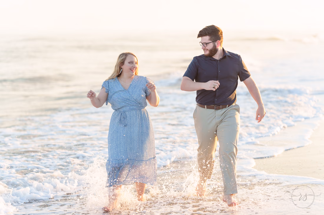 Couple running through the edge of the surf - Huntington Beach State Park