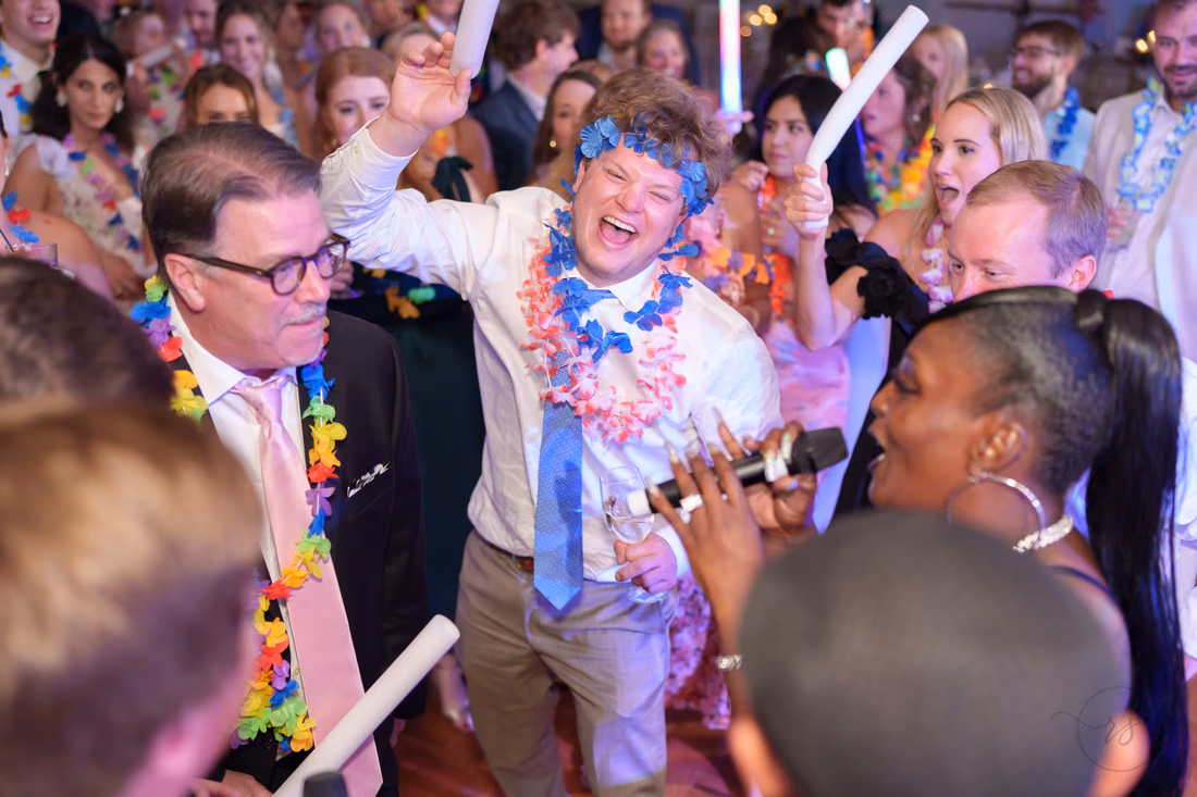 A guest in a bandana and lei sings along with the band at Pawleys Plantation