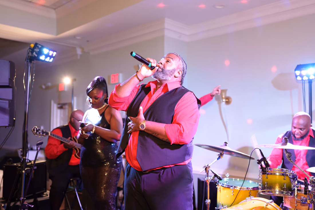 Band's lead singer and drummer perform on stage at Pawleys Plantation