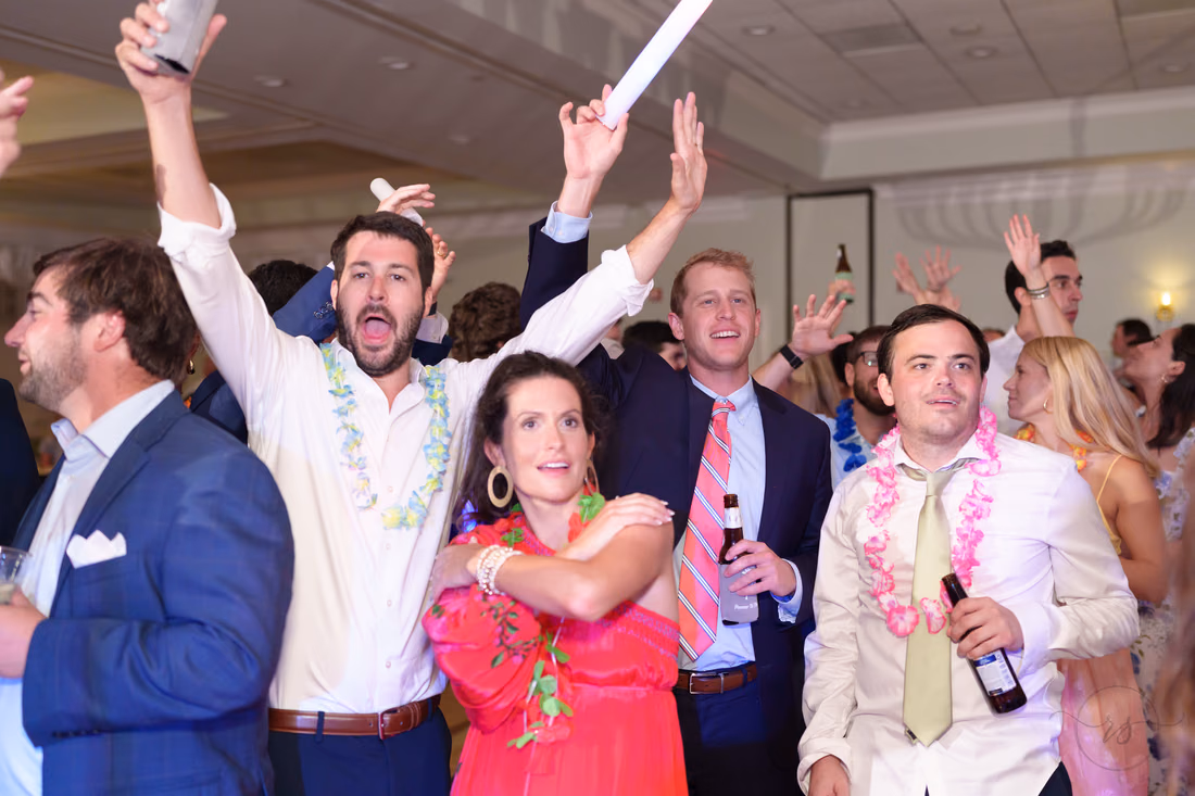 Guests in leis cheer and sing along at the reception at Pawleys Plantation