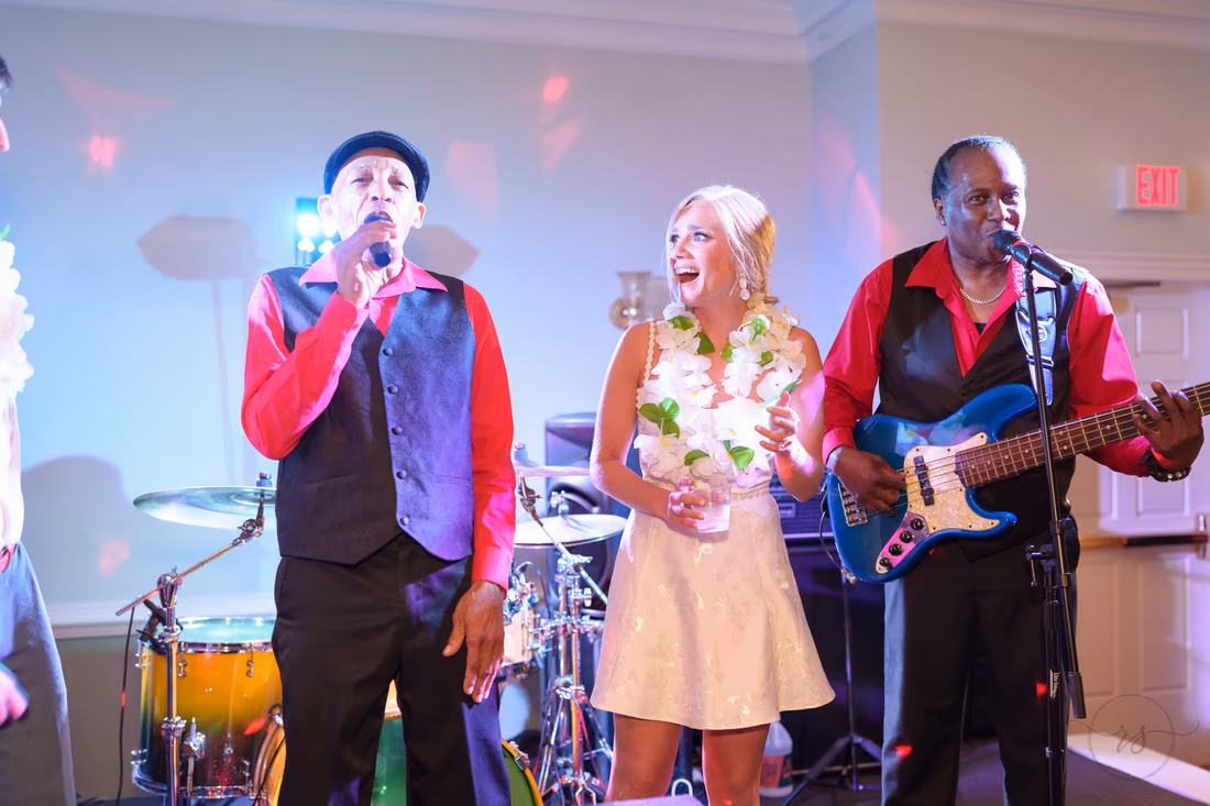 Bride sings on stage with the band's singer and bassist at Pawleys Plantation