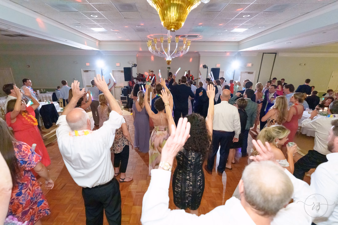 Guests raise their hands on a packed dance floor at Pawleys Plantation