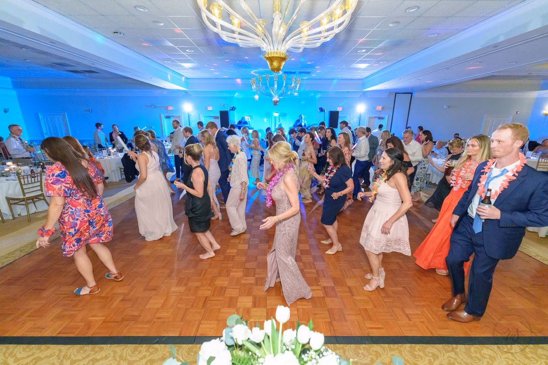 Guests dance under blue uplighting in the ballroom at Pawleys Plantation