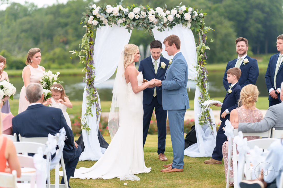 Bride and groom holding hands during the ceremony - Pawleys Plantation