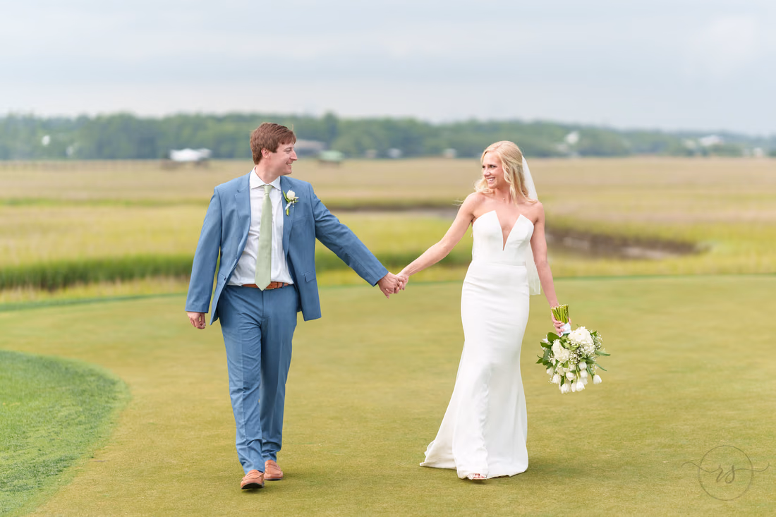 Groom leads the bride by the hand along the golf course at Pawleys Plantation