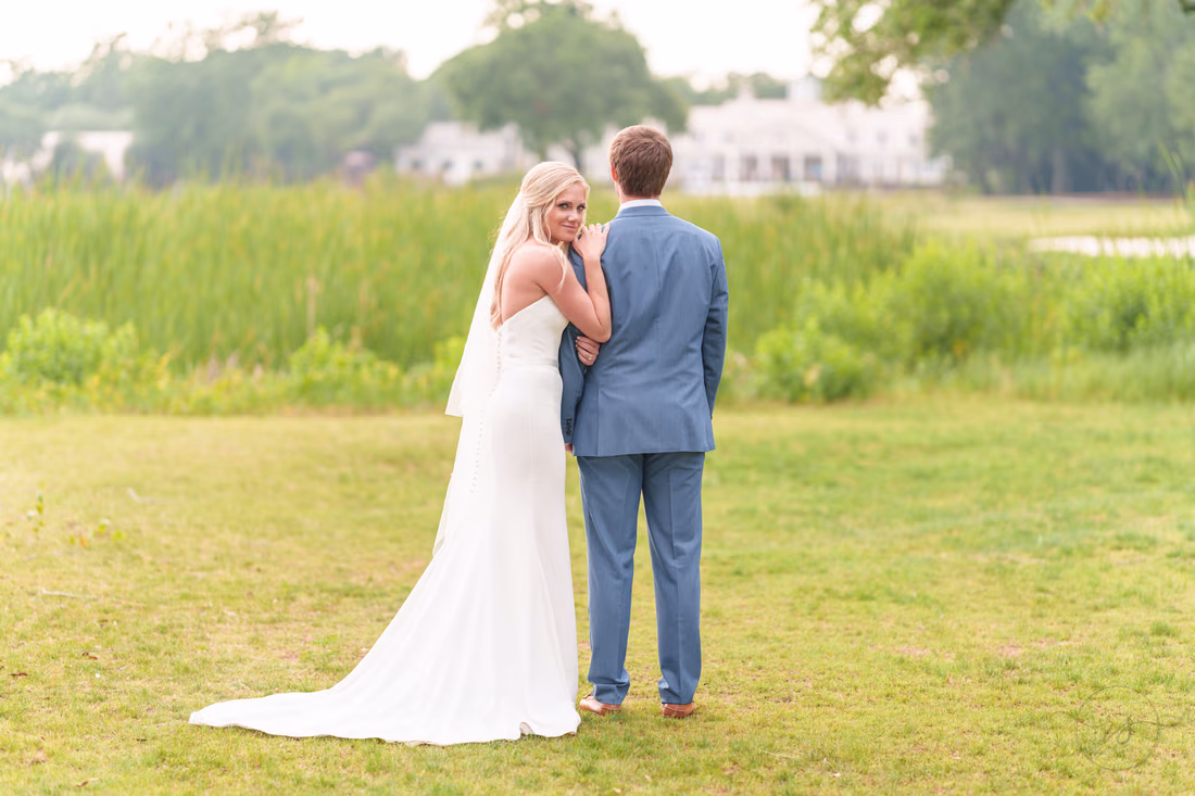 Bride looking back with hand on groom's shoulder - Pawleys Plantation