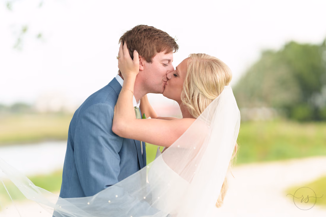 Bride pulling groom in for a kiss - Pawleys Plantation