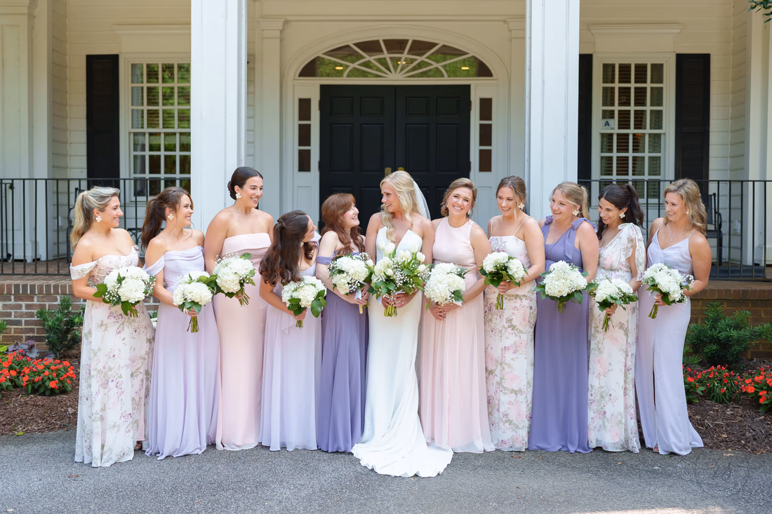 Bride and bridesmaids laugh together in front of the clubhouse at Pawleys Plantation