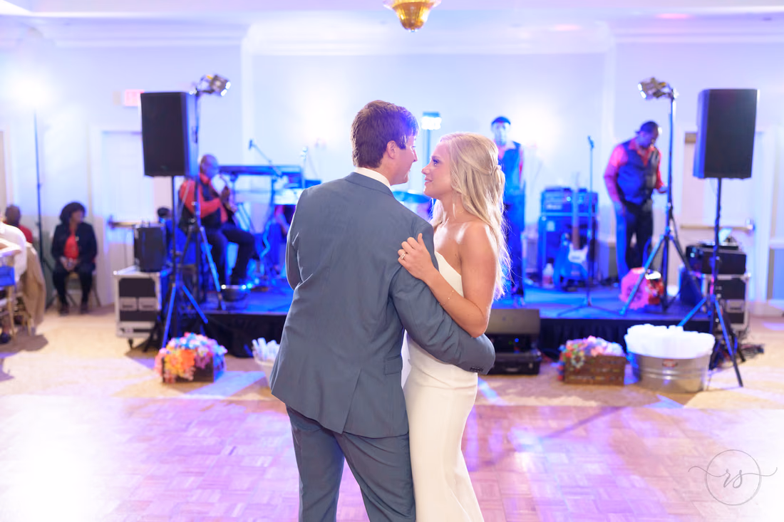 Bride and groom share their first dance in front of the band's stage at Pawleys Plantation