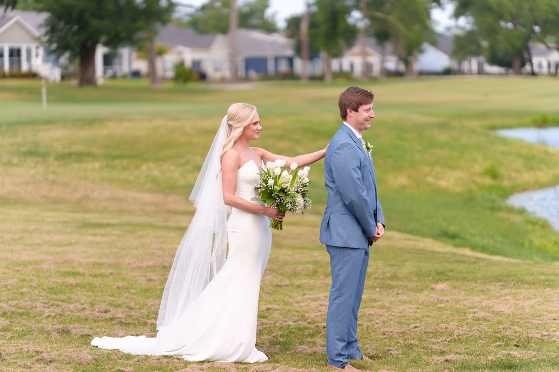 Bride taps the groom on the shoulder for their first look on the golf course at Pawleys Plantation