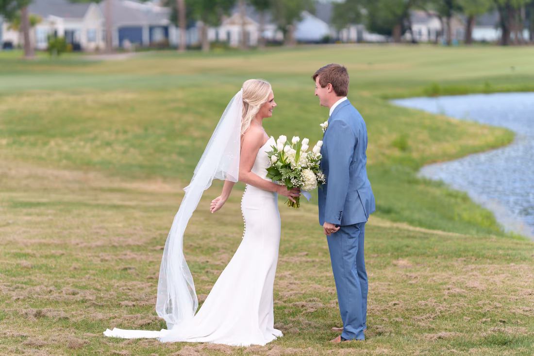Groom turns to see the bride for the first time beside a pond at Pawleys Plantation