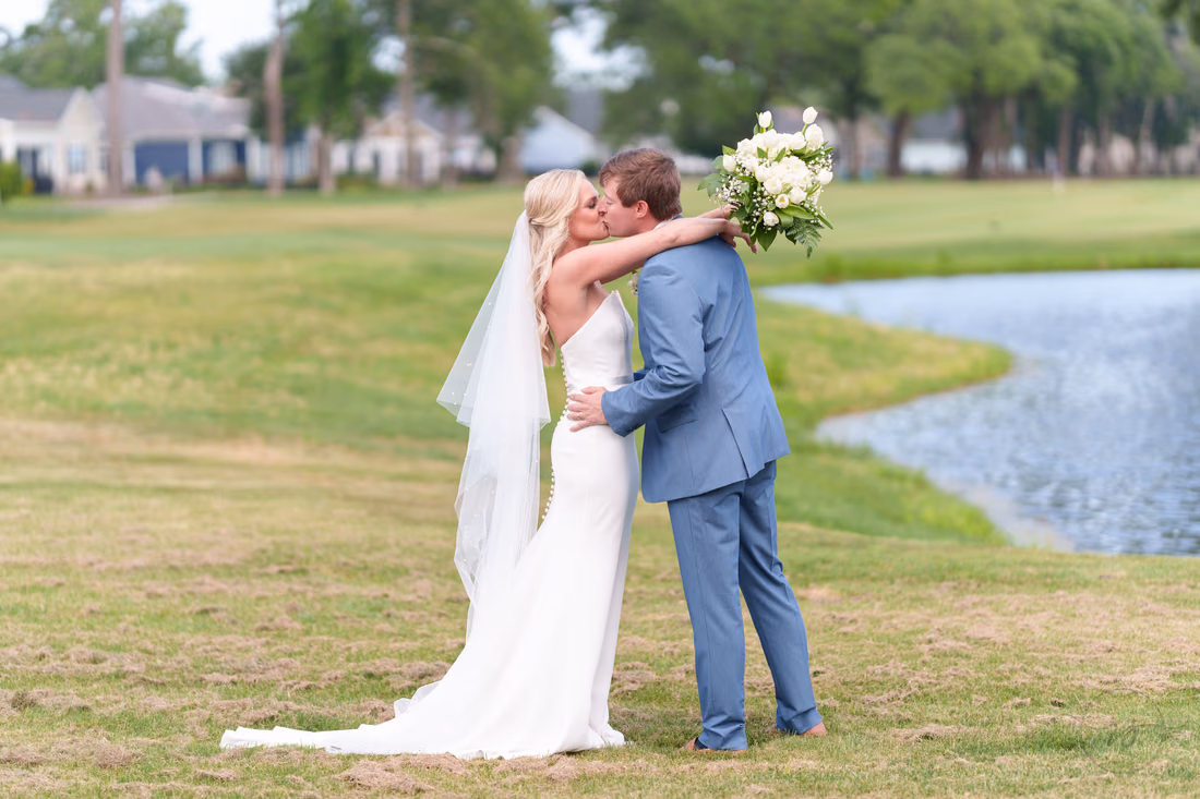 Bride and groom kiss and hug during their first look at Pawleys Plantation