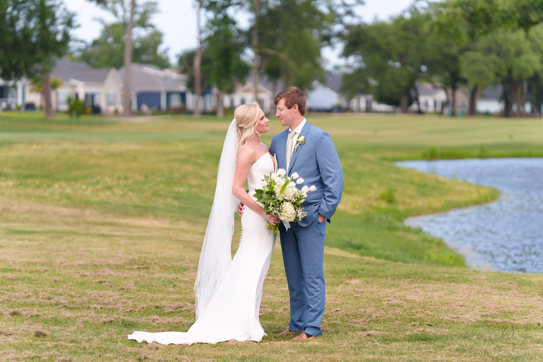 Bride and groom smile at each other by the pond after their first look at Pawleys Plantation