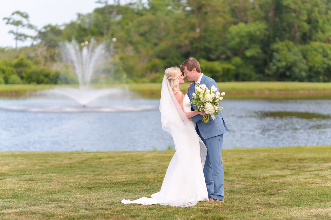 Bride and groom touch foreheads in front of the pond fountain at Pawleys Plantation