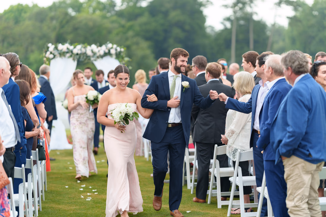 Wedding party recesses up the aisle as guests offer fist bumps at Pawleys Plantation