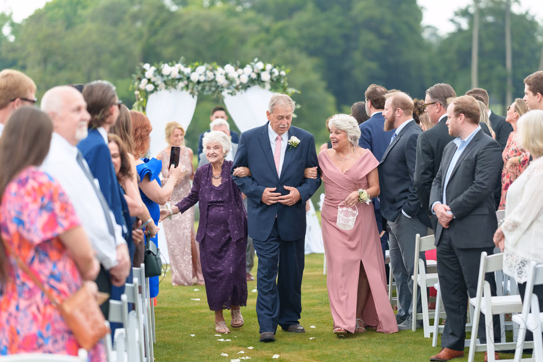 Family members walk back up the aisle trading fist bumps with guests at Pawleys Plantation