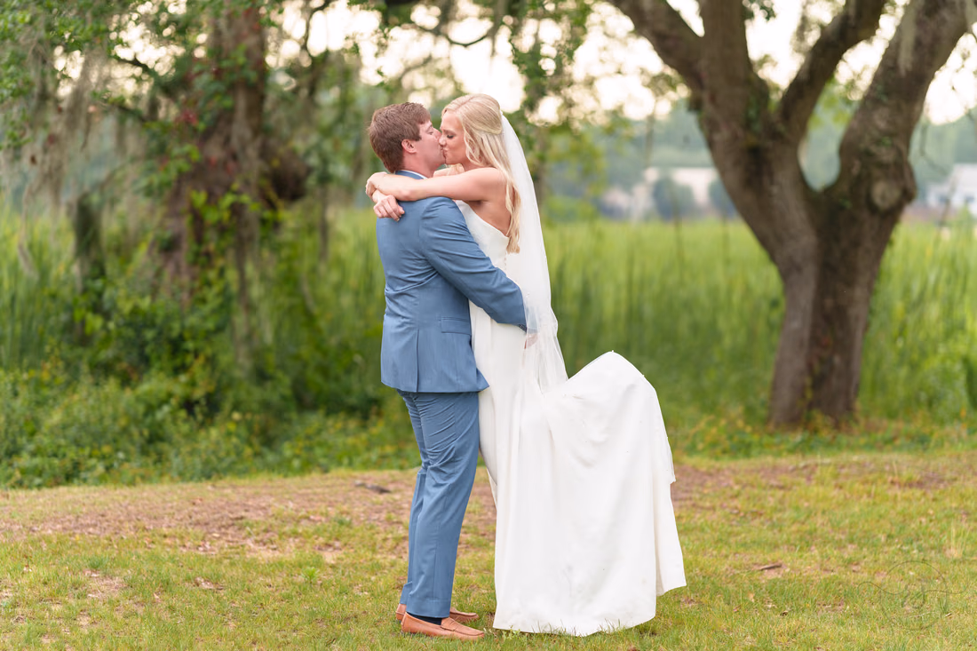 Groom lifting bride into the air - Pawleys Plantation
