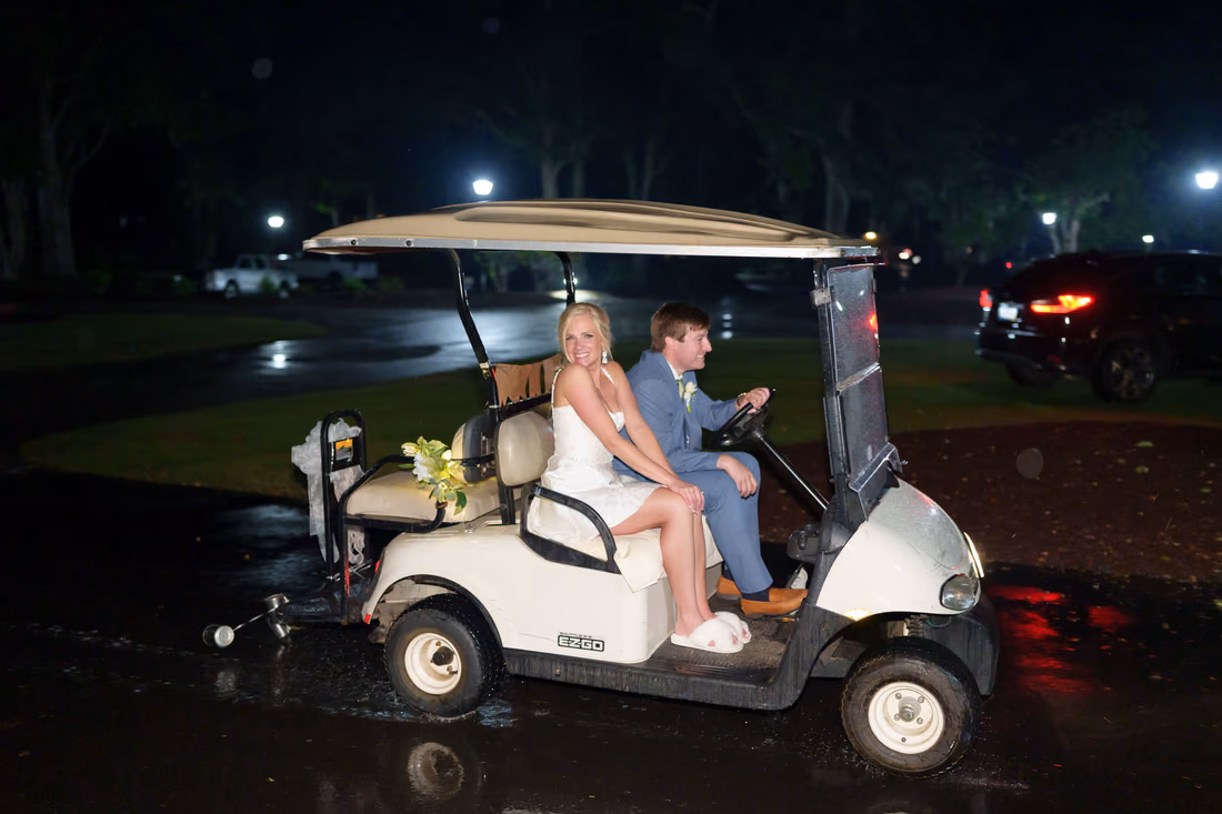 Bride and groom ride off on a golf cart at night after the reception at Pawleys Plantation