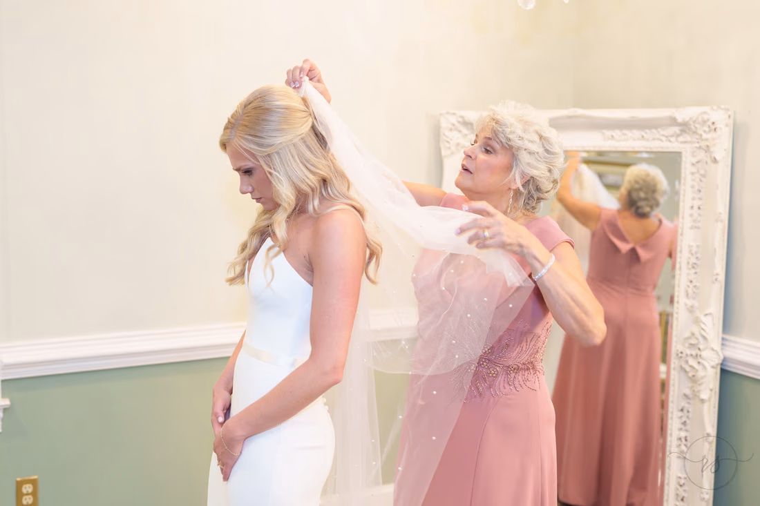 Mom adjusts the bride's veil in front of the mirror at Pawleys Plantation