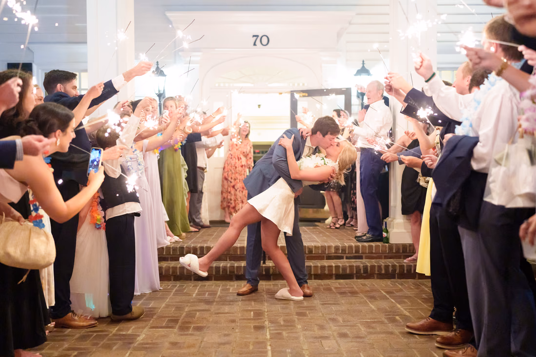 Groom dips the bride for a kiss under a tunnel of sparklers at Pawleys Plantation