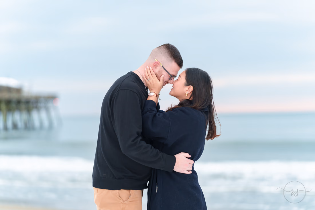 Couple kissing by the ocean with the pier behind - Garden City Beach