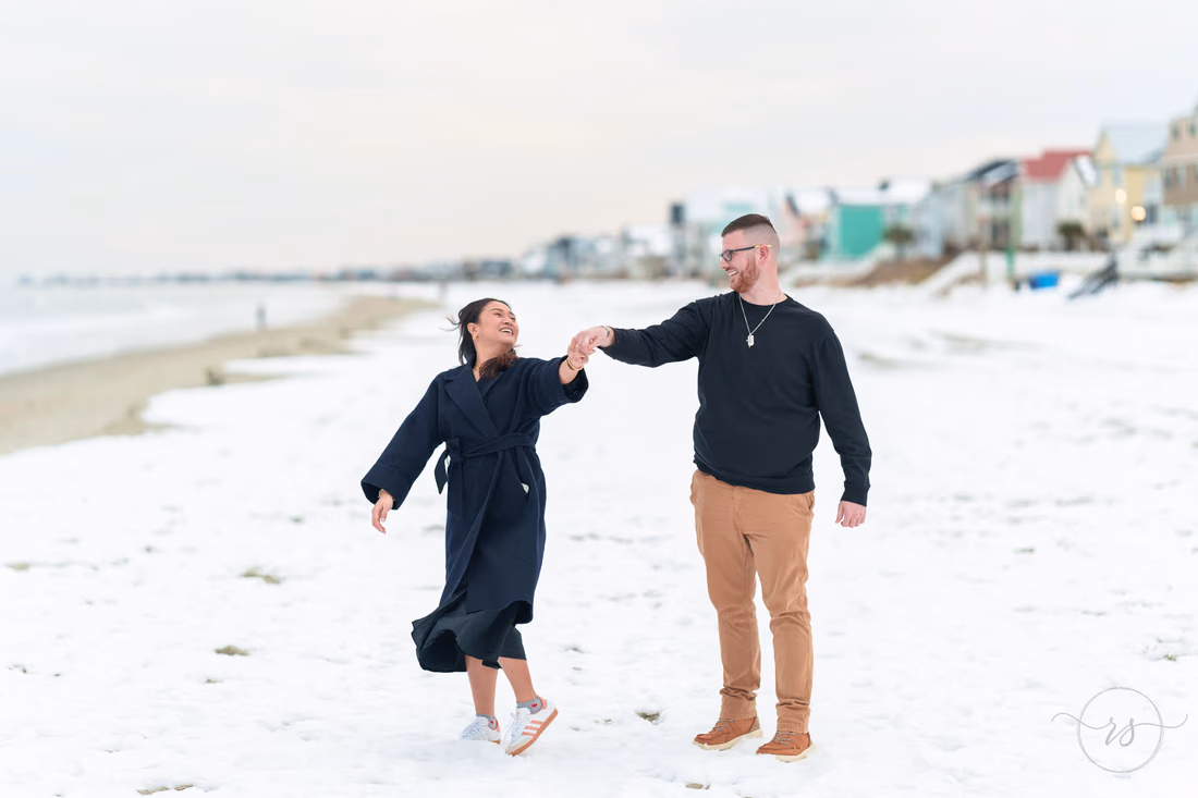 Couple dancing on the snow-covered beach by the beach houses - Garden City Beach