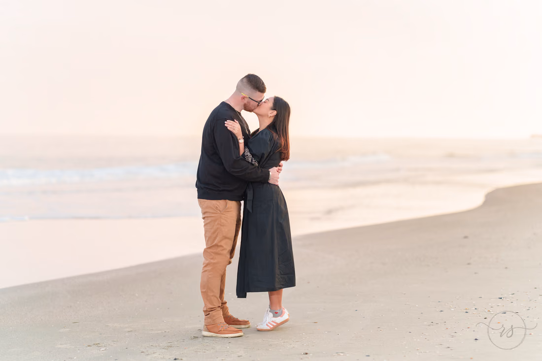 Couple sharing a kiss by the water at sunset - Garden City Beach
