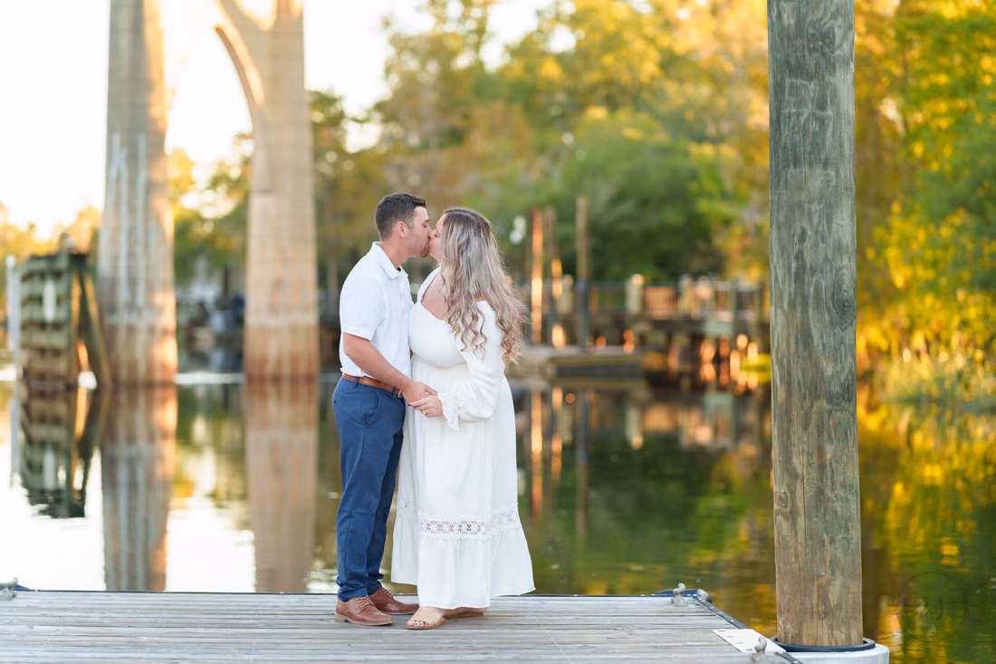 Couple kissing on the dock with the river behind - Conway Riverwalk